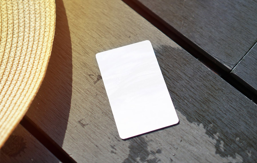 Don't forget your pool pass to to take a refreshing swim at City Flats on Walnut. Summer hat and key card on a deck floor.