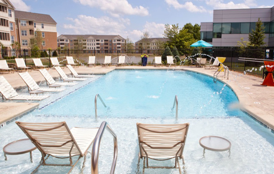 A beautiful blue pool enhances your apartment experience in Bloomington. Lake side pool on a sunny day.