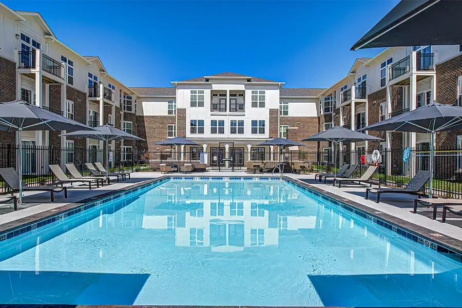 Pristine pool surrounded by apartment buildings at City Flats on Walnut Apartments.